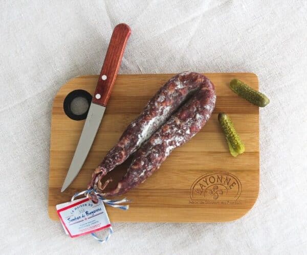 Planche à découper, son couteau et une saucisse sèche